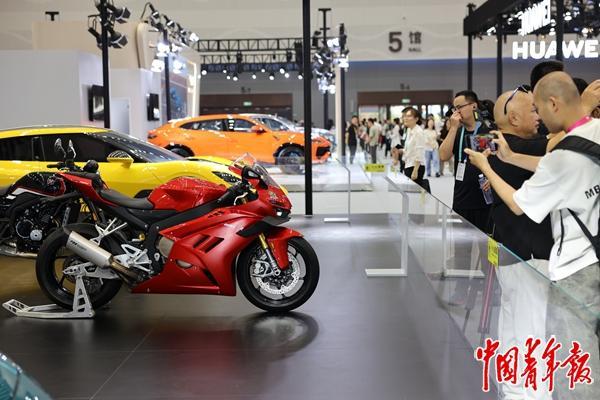 4月14日，海南海口，海南国际会展中心，第六届消博会免税与高端精品展区，张雪机车吸引了众多参观者的关注。前不久，在世界超级摩托车锦标赛葡萄牙站，来自中国重庆的张雪机车在中量级组别中包揽两回合冠军，打破了欧洲、日本等厂商对这一赛事长达数十年的垄断。在本届消博会上，各个国家和地区的“新、奇、特、酷”消费精品争相亮相，为参观者带来充满新鲜感的观展体验。中青报·中青网记者 曲俊燕/摄 